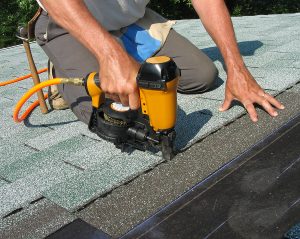 Re-Roofing contractor using nail gun